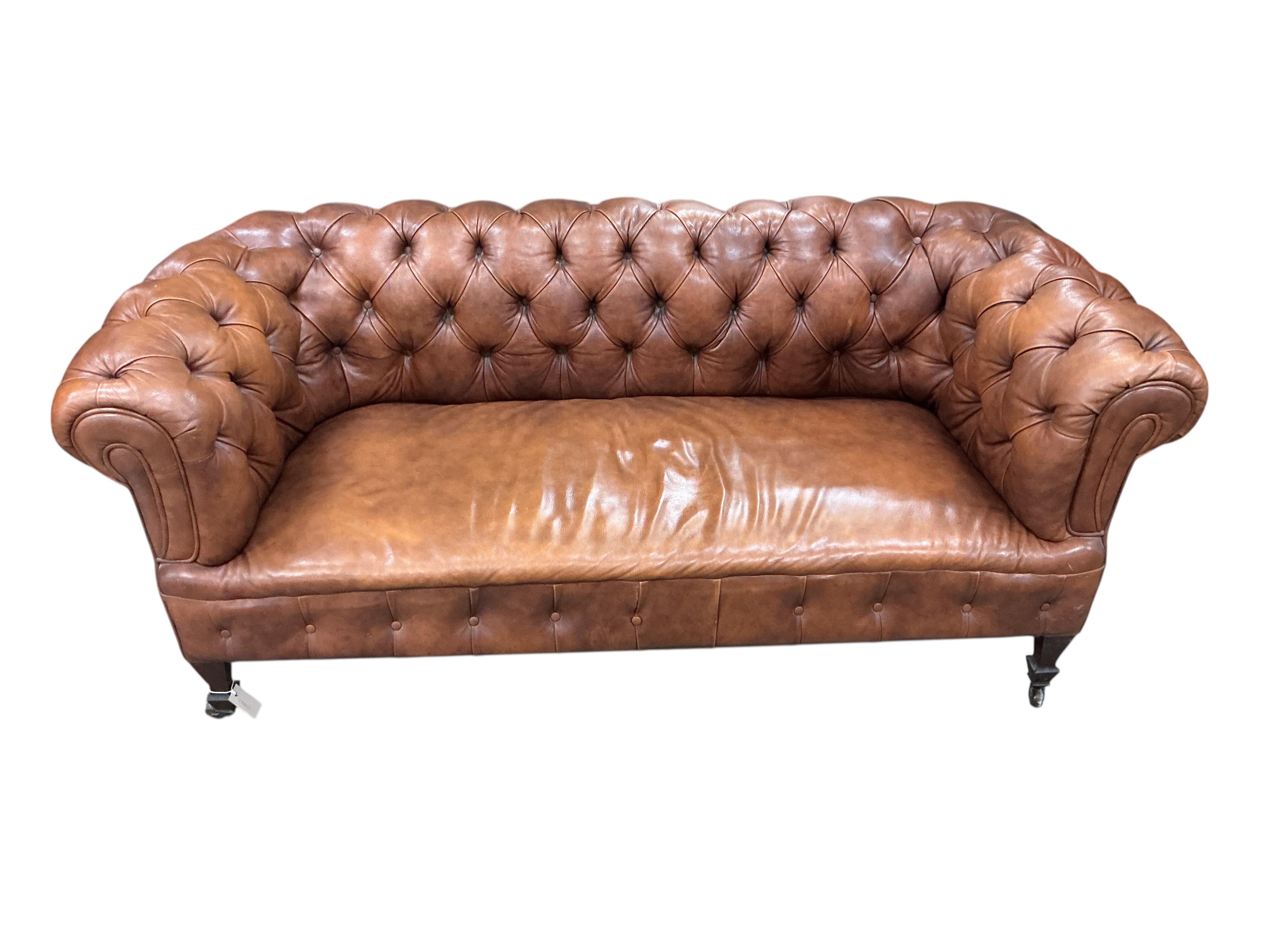 An early 20th century buttoned brown leather Chesterfield settee, width 180cm, depth 78cm, height 71cm
